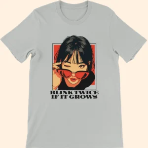 Silver T-shirt featuring an illustrated woman wearing red sunglasses with the text Blink Twice If It Grows on the front
